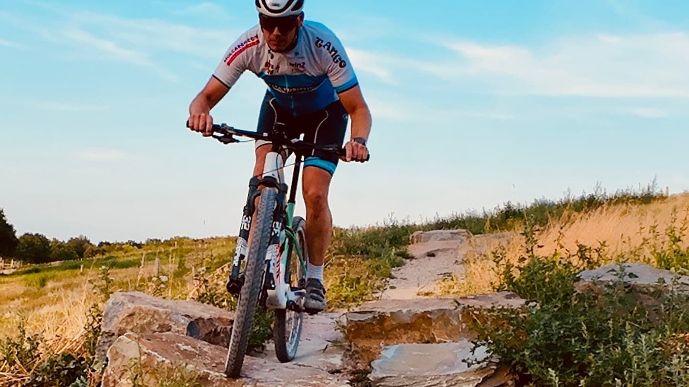 Mountainbiker daalt af over een trap van natuursteenblokken